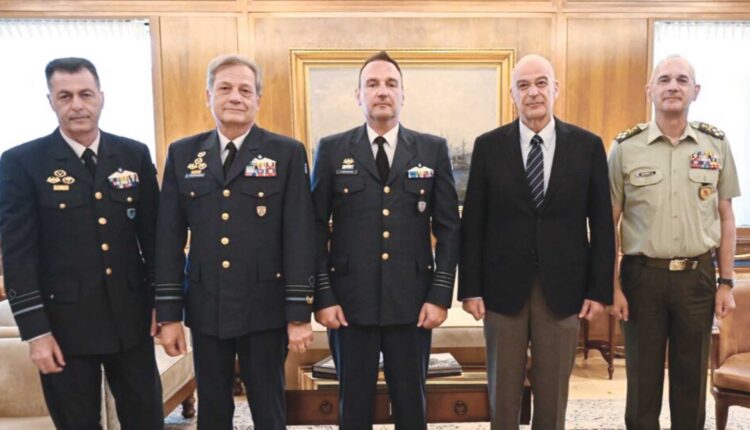 Ὁ ἀντισμήναρχος Γιῶργος Χατζόπουλος (στήν μέση) πλαισιωμένος ἀπό τήν πολιτική καί στρατιωτική ἡγεσία.