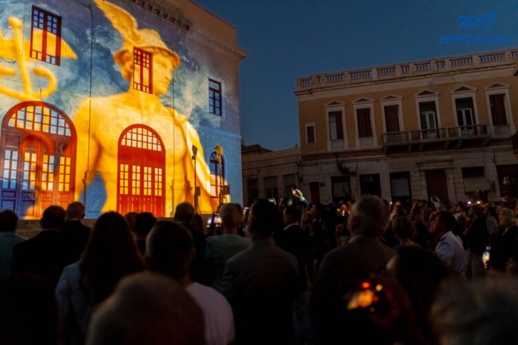 Η μορφή του Ερμή προβάλλεται στο Θέατρο Απόλλων, μετατρέποντας την πρόσοψη σε σκηνή μνήμης και εικόνας.